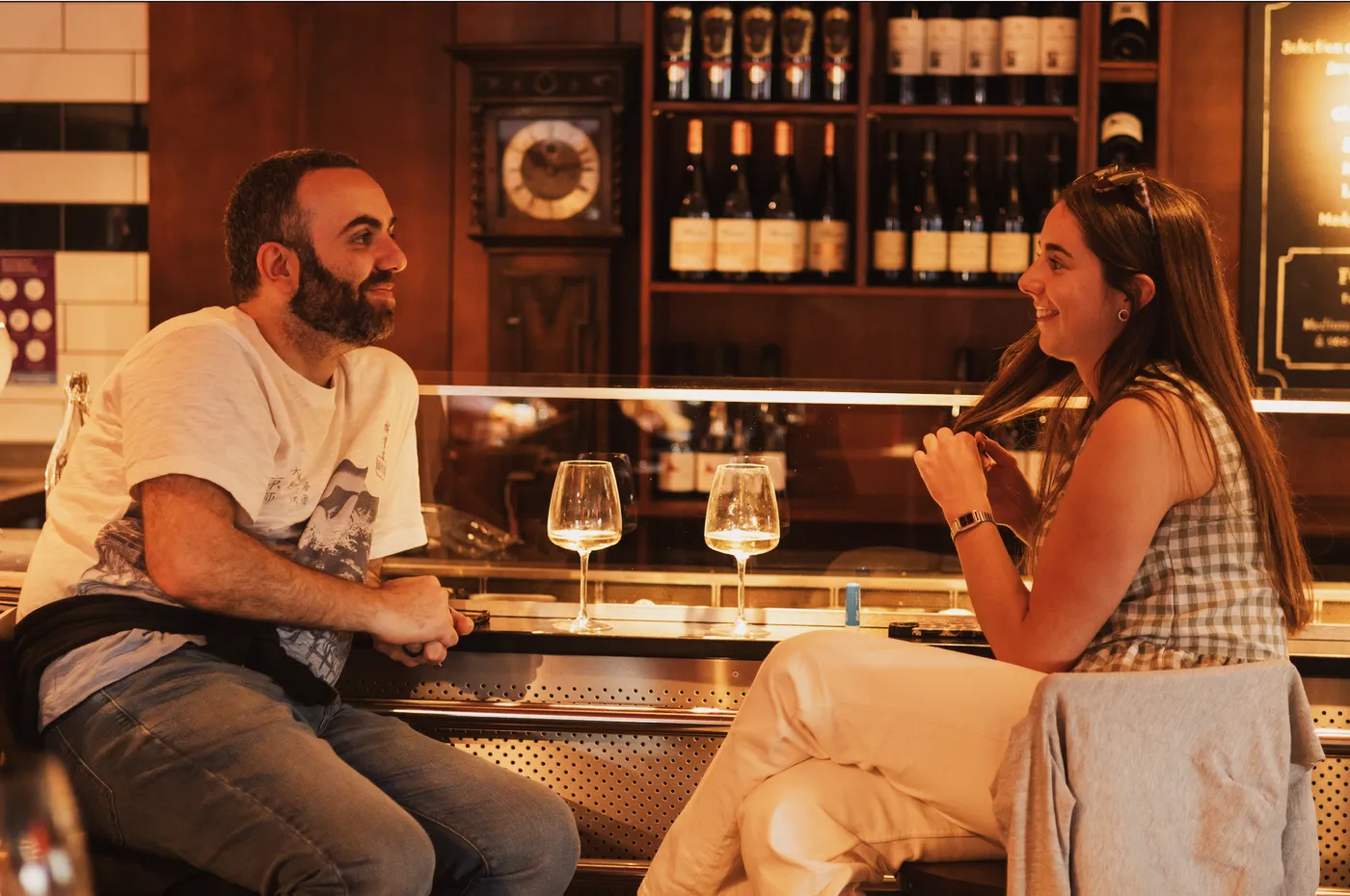 Two guests sharing a bottle of wine at the bar at Chez Bernard