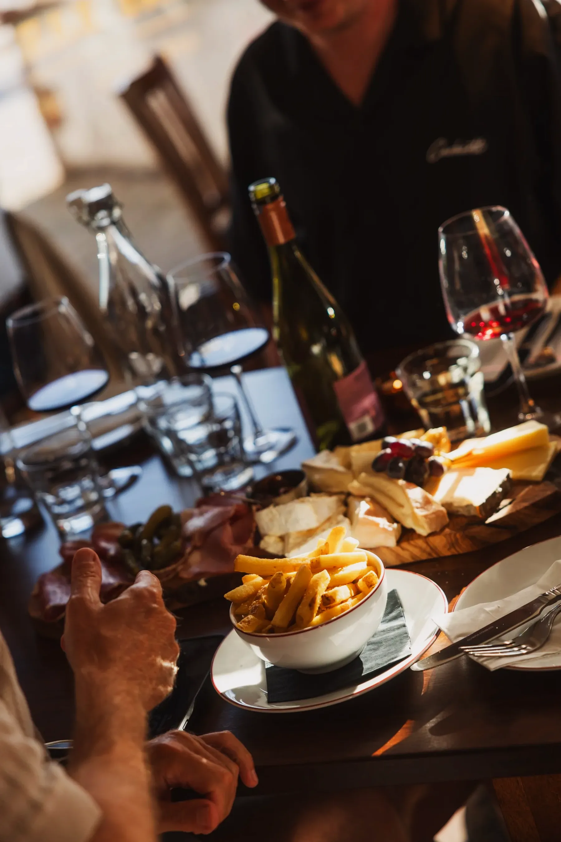 A shared table of wine, bread and small plates at Chez Bernard