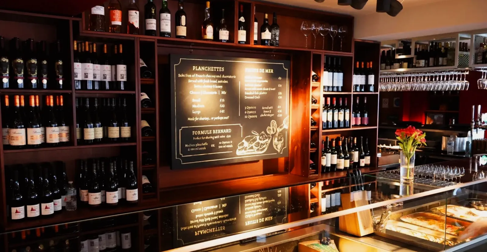 The illuminated wine wall and deli counter at Chez Bernard